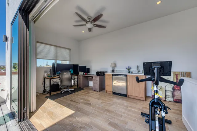 a view of a workspace with furniture and a window
