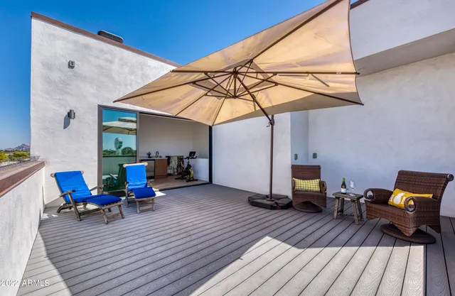 a view of a rooftop with chairs and a table