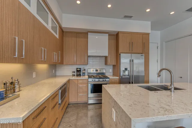 a kitchen with stainless steel appliances granite countertop a sink stove and refrigerator