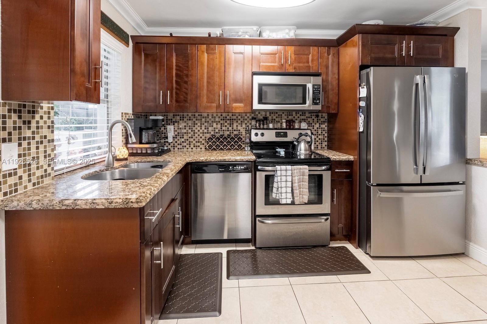 7002 Northwest 95th Avenue Tamarac, FL 33321 - Photo 4 of 12 a kitchen with a refrigerator sink and microwave
