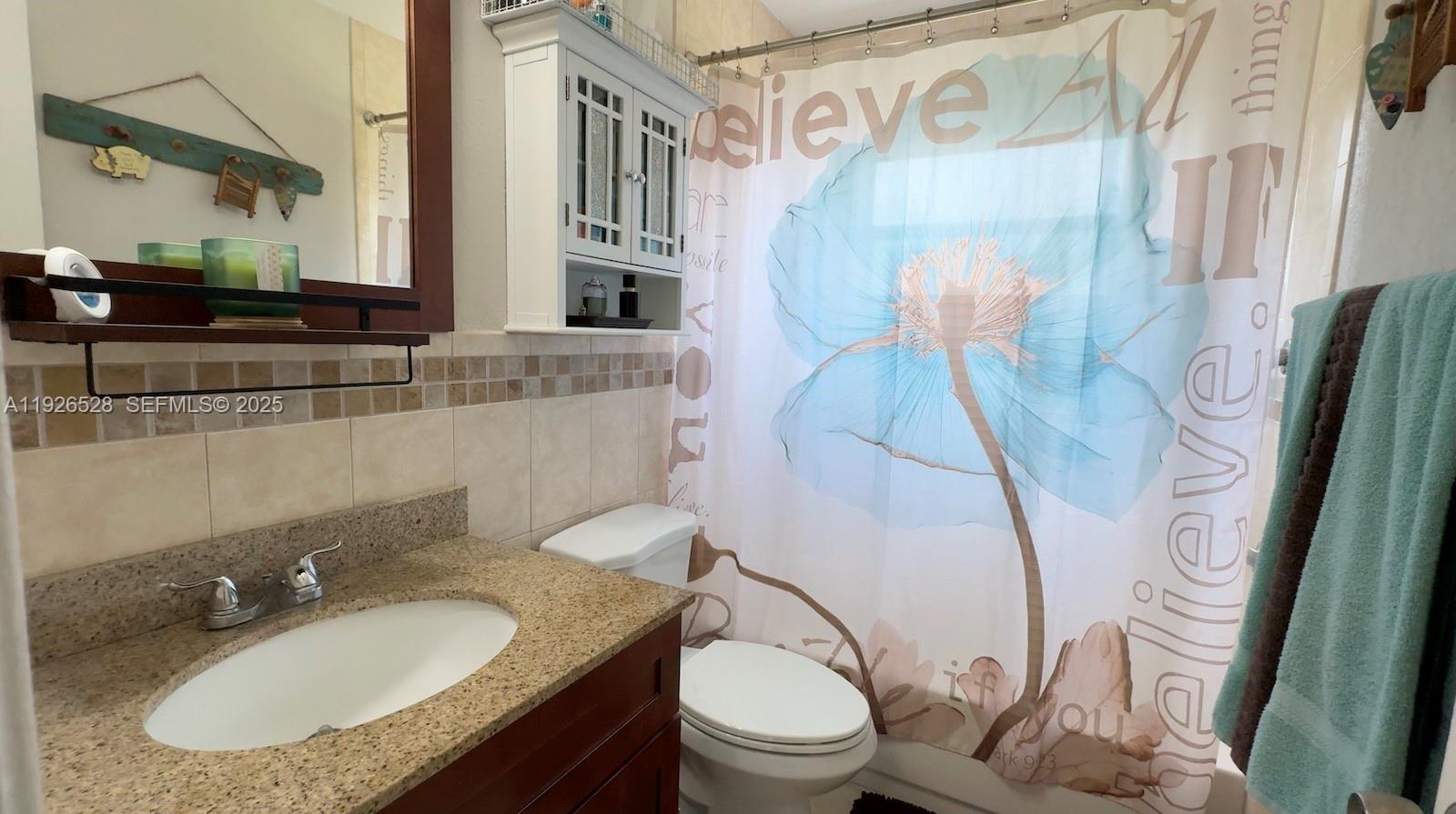 7002 Northwest 95th Avenue Tamarac, FL 33321 - Photo 7 of 12 a bathroom with a granite countertop sink toilet and a mirror