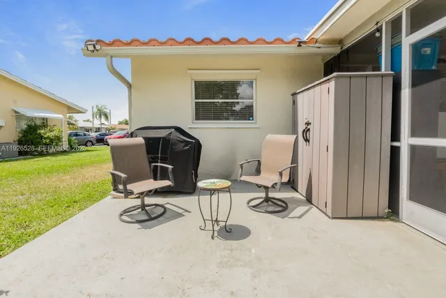 a view of a livingroom with chairs and a table in a patio