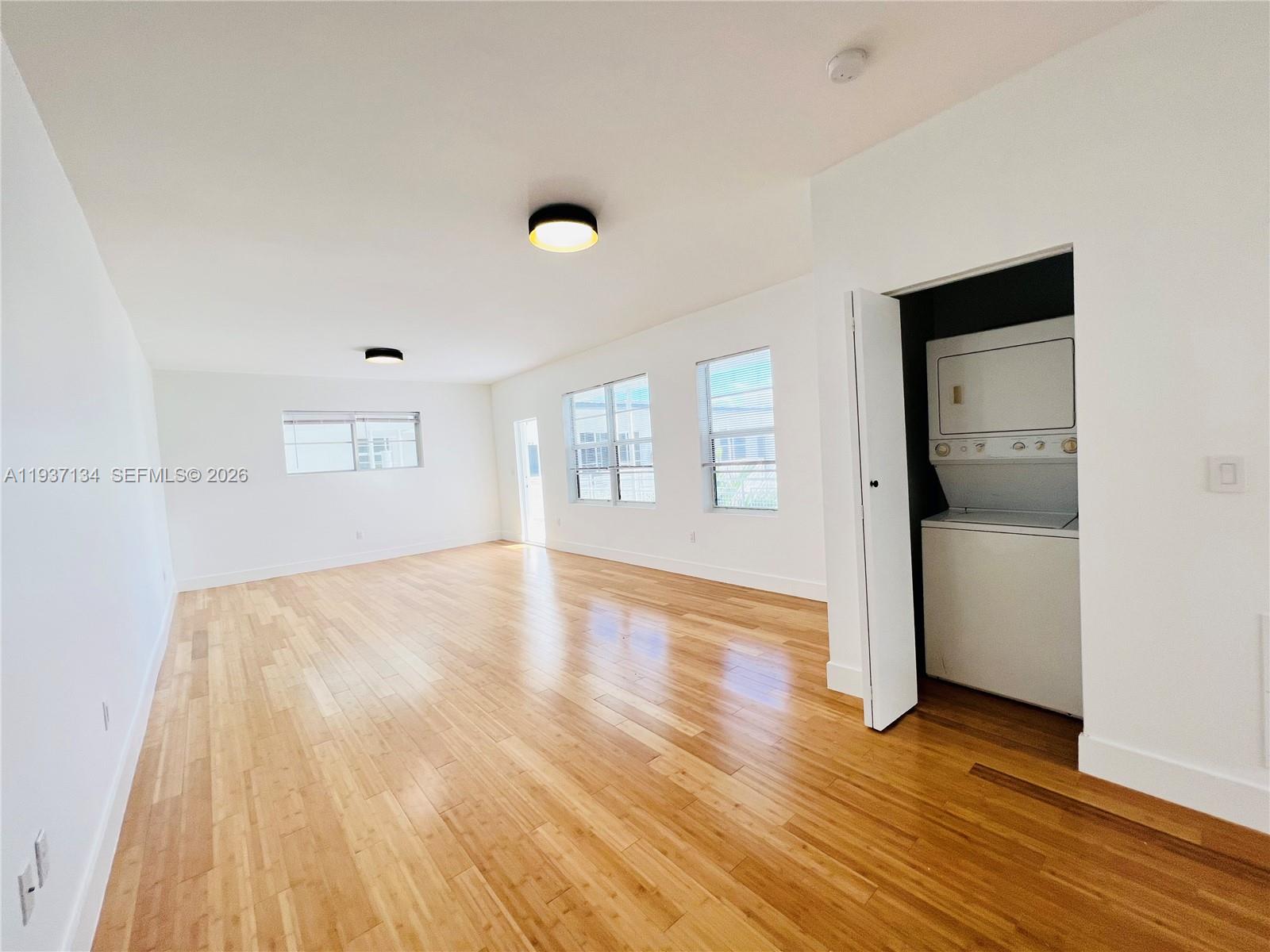 960 Bay Drive, Unit 902 Miami Beach, FL 33141 - Photo 10 of 23 an empty room with wooden floor and windows