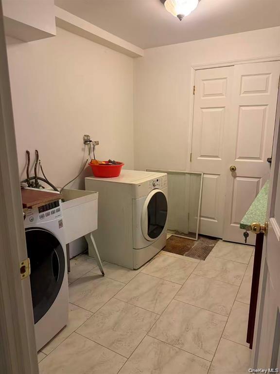 154-60 Riverside Drive Queens, NY 11357 - Photo 16 of 17 a room with a washing machine and dryer