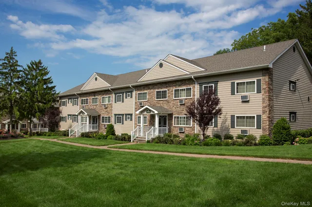 a front view of a house with a garden and trees