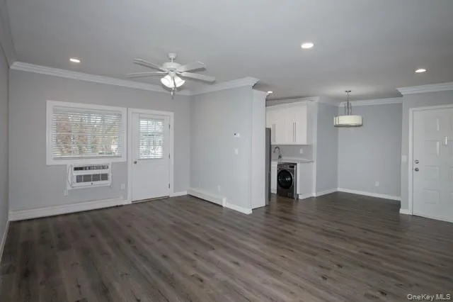 a view of an empty room with a window and wooden floor