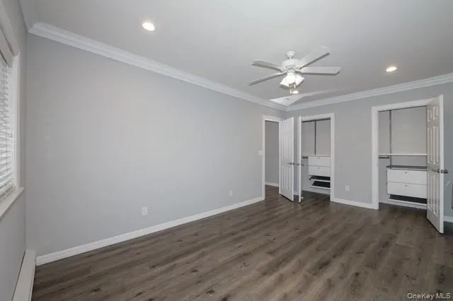 an empty room with wooden floor ceiling fan and windows