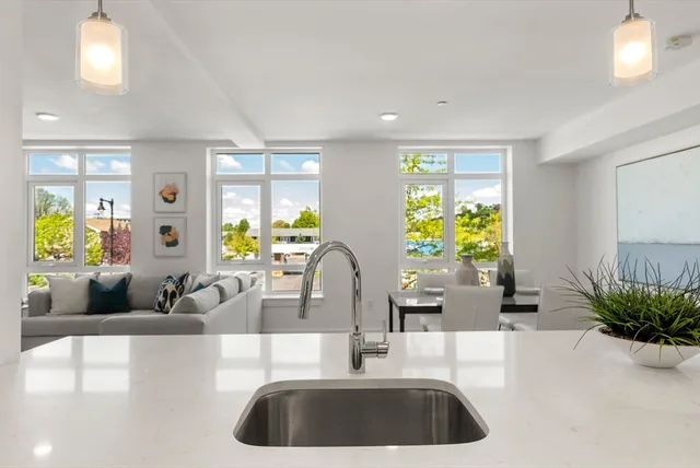 a kitchen with granite countertop a couch a potted plant and a large window