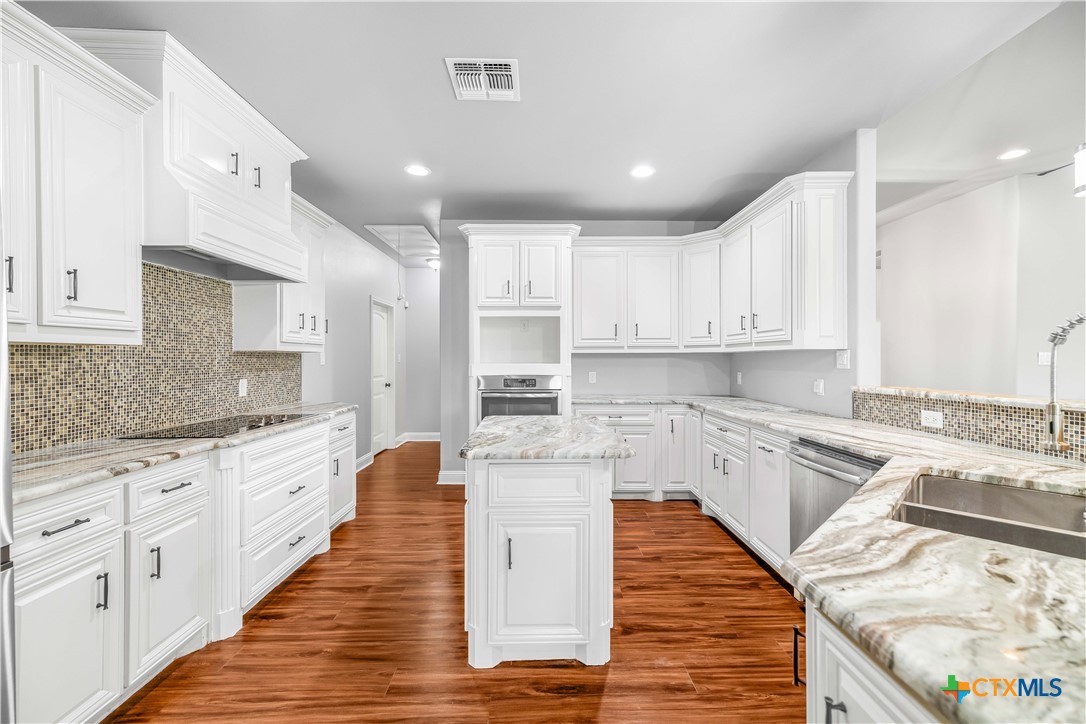 204 James Street Inez, TX 77968 - Photo 9 of 35 a large white kitchen with stainless steel appliances granite countertop a stove and a sink
