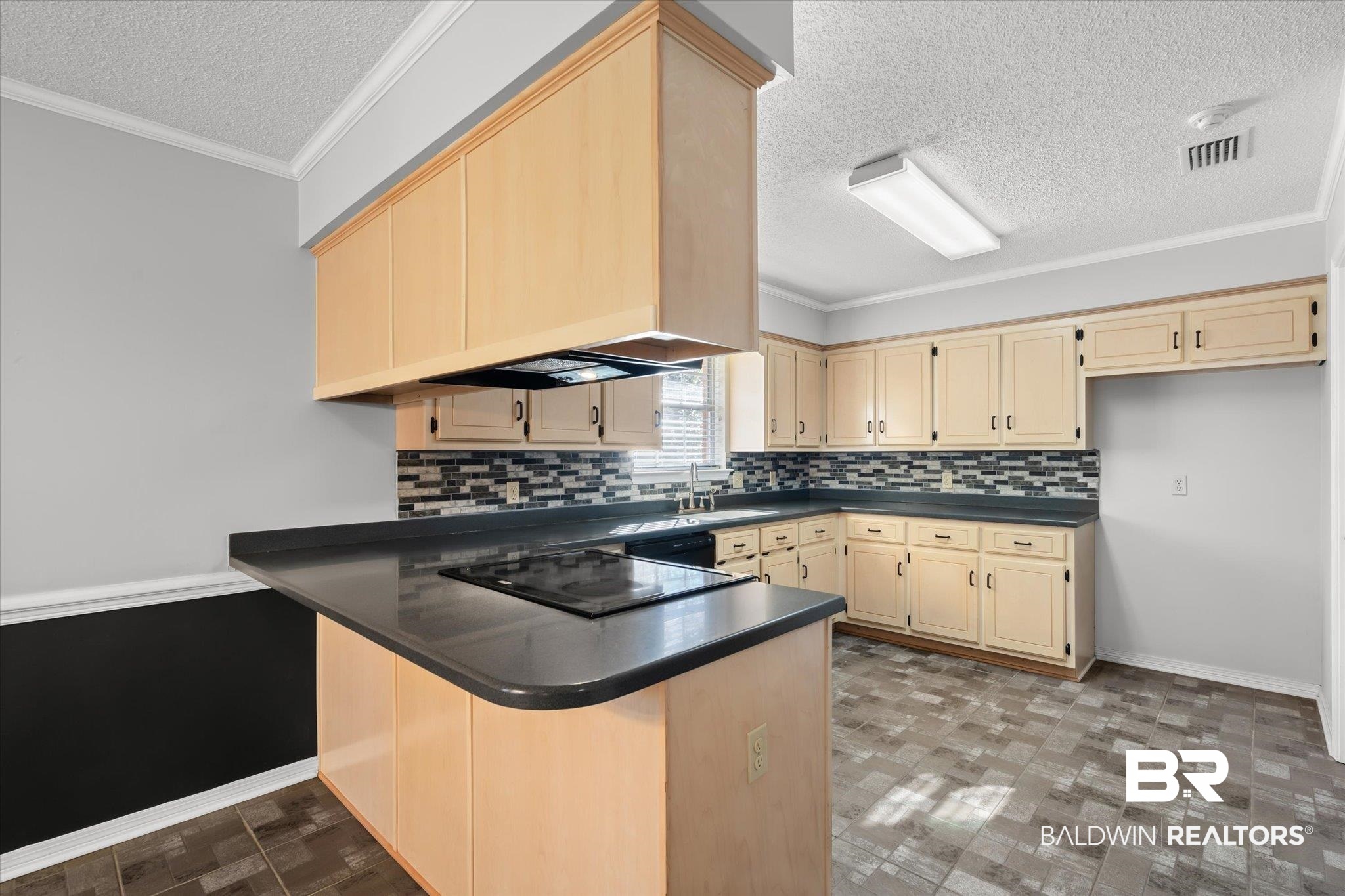 7410 East Lakeview Drive Mobile, AL 36695 - Photo 4 of 20 Kitchen with custom exhaust hood, black electric stovetop, sink, ornamental molding, and kitchen peninsula