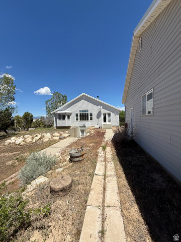 10000 North 6730th East Spring City, UT 84662 - Photo 23 of 31 The property features a primary building with light-colored siding and a gable roof