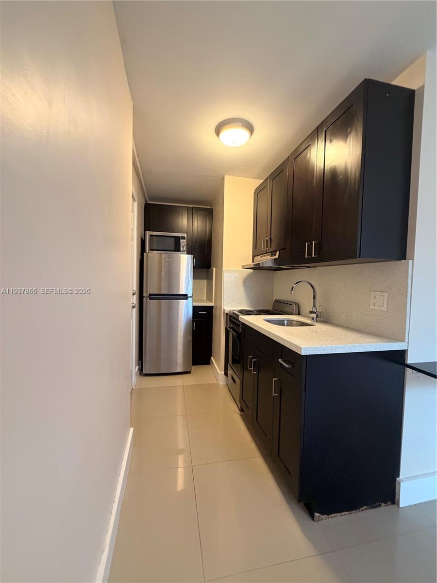 15337 Southwest 62nd Terrace, Unit B Miami, FL 33193 - Photo 3 of 9 a kitchen with stainless steel appliances granite countertop a refrigerator and a sink