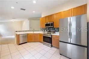 a kitchen with stainless steel appliances granite countertop a refrigerator sink and stove