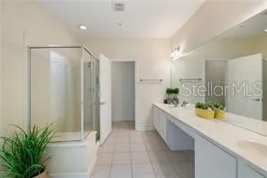 a bathroom with a granite countertop sink a toilet a mirror and shower
