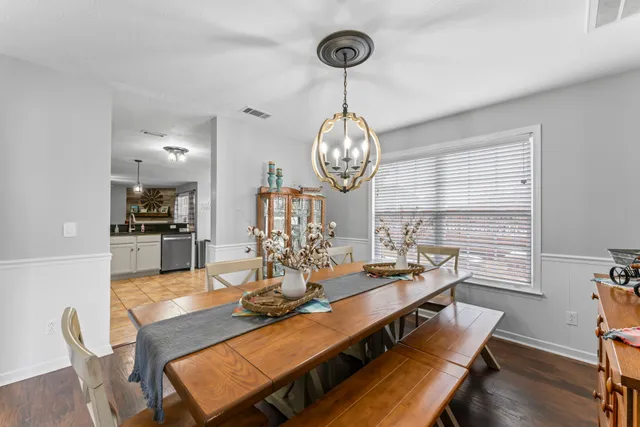 a view of a dining room with furniture wooden floor and chandelier