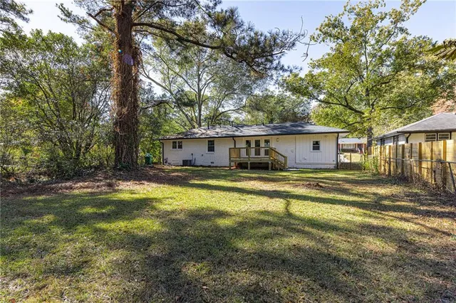 a view of a house with pool and a yard