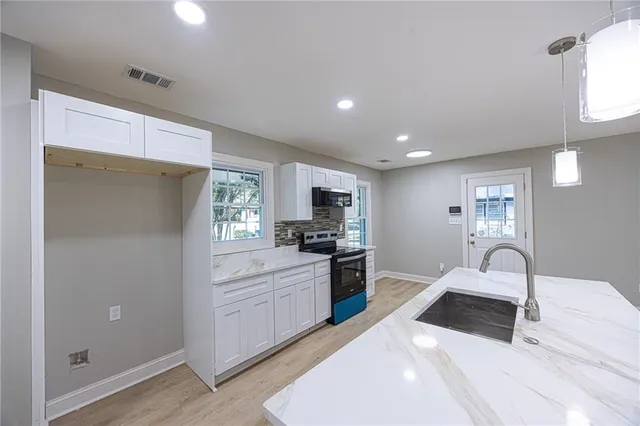 a kitchen with stainless steel appliances a refrigerator sink and microwave