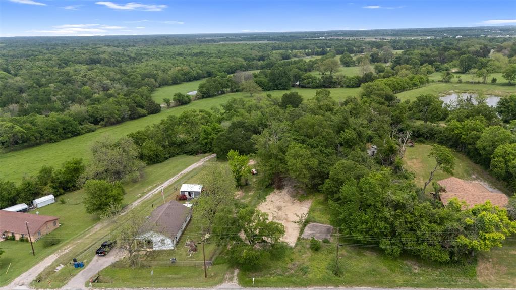 706 West Pyle Street Kaufman, TX 75142 - Photo 2 of 6 an aerial view of green landscape with trees houses and mountain view