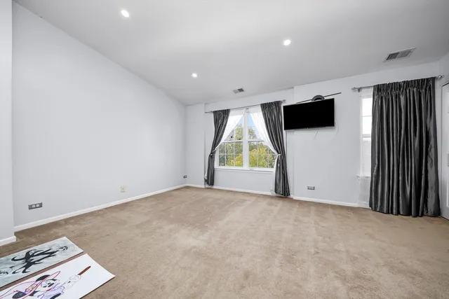 an empty room with windows and a flat screen tv