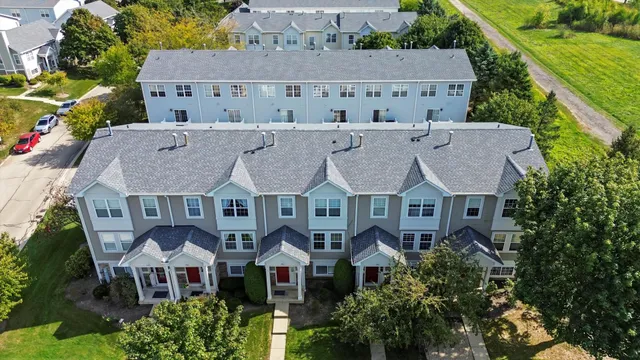 an aerial view of residential houses with outdoor space and seating area
