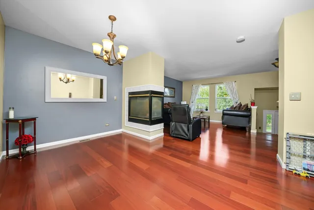 a view of a livingroom with furniture a chandelier wooden floor and a chandelier