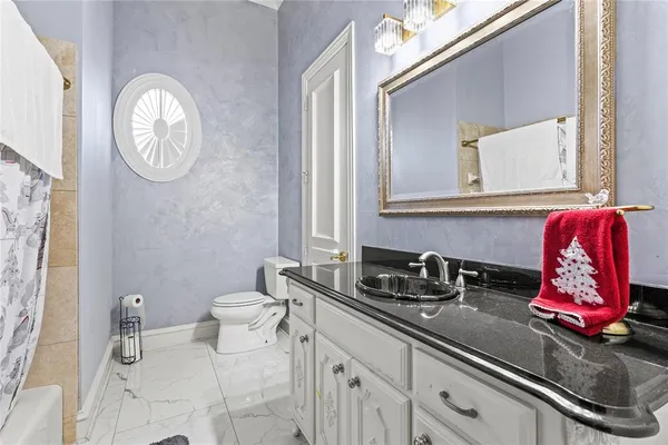 a bathroom with a toilet sink vanity and mirror
