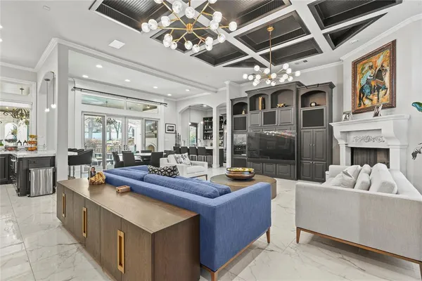 a living room with fireplace furniture and a chandelier