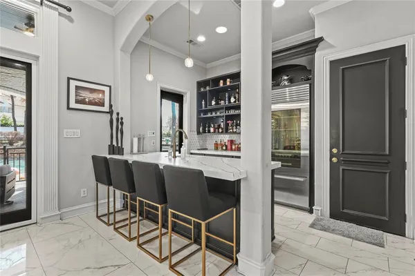 a dining room with stainless steel appliances kitchen island granite countertop a refrigerator and cabinets
