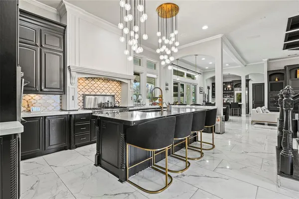 a kitchen with a dining table chairs and chandelier