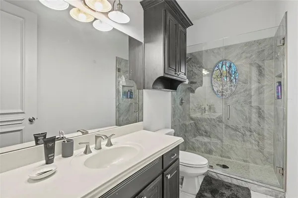 a bathroom with a sink a toilet and shower