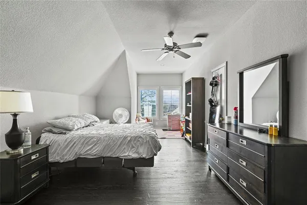 a bedroom with a bed and dresser with mirror