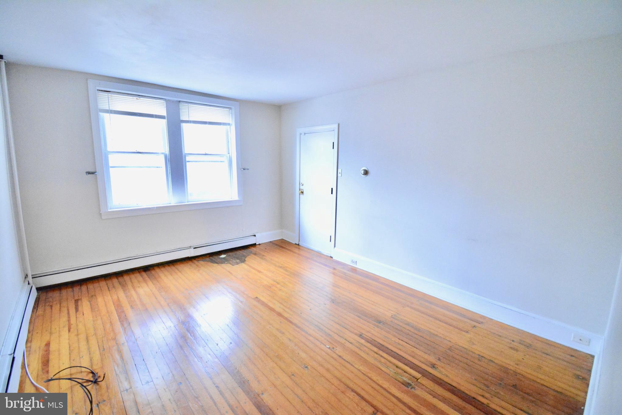 3694 Calumet Street, Unit 1 Philadelphia, PA 19129 - Photo 4 of 18 an empty room with wooden floor and windows