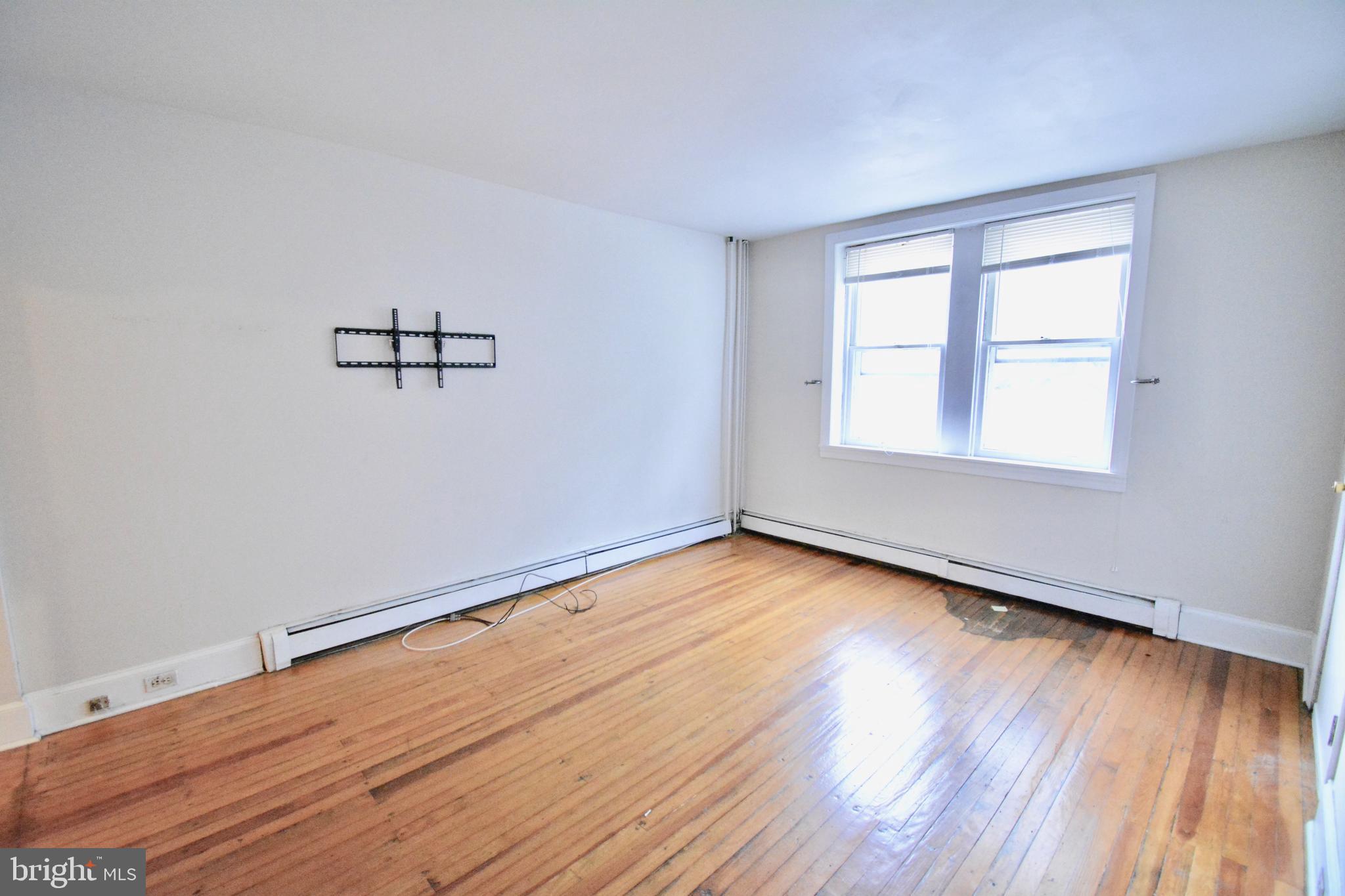 3694 Calumet Street, Unit 1 Philadelphia, PA 19129 - Photo 5 of 18 an empty room with wooden floor and windows