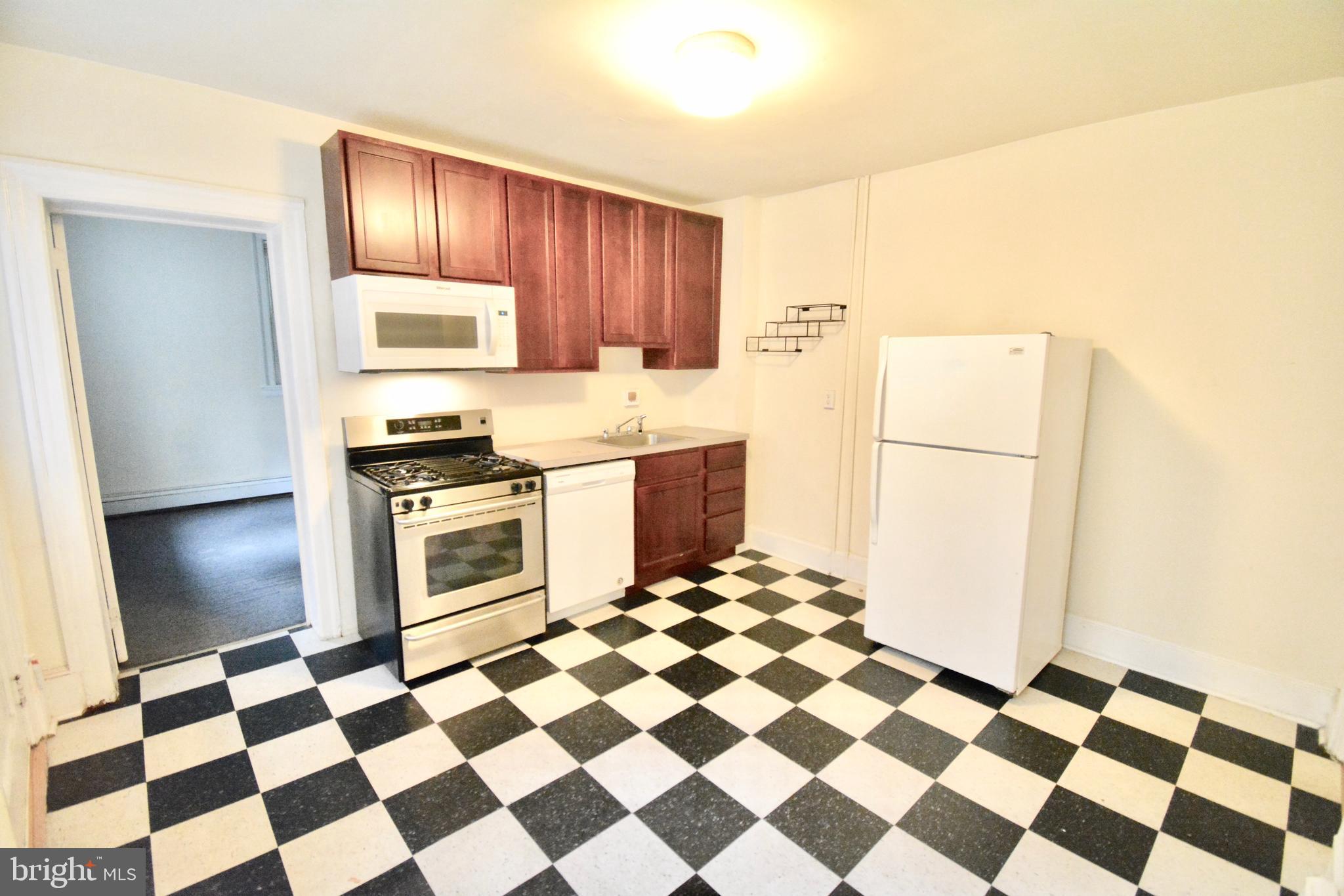 3694 Calumet Street, Unit 1 Philadelphia, PA 19129 - Photo 10 of 18 a kitchen with a checkered floor and steel appliances