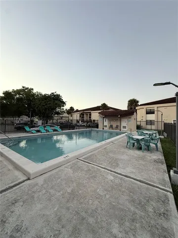 a view of a backyard with wooden fence and large trees