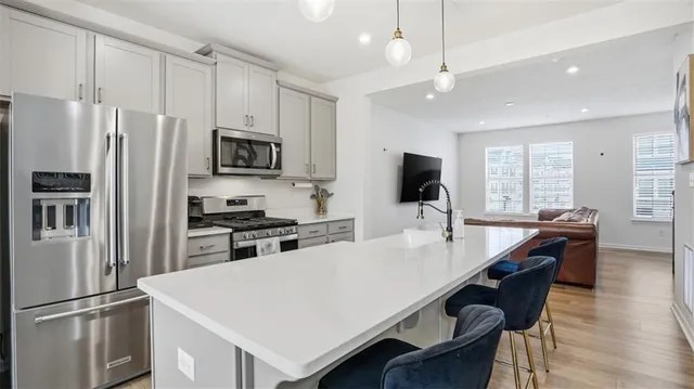 a kitchen with stainless steel appliances a stove refrigerator sink and microwave