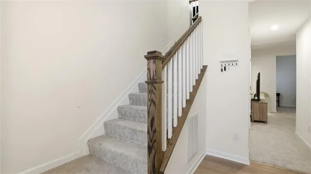 a view of staircase with lots of frames on wall and windows