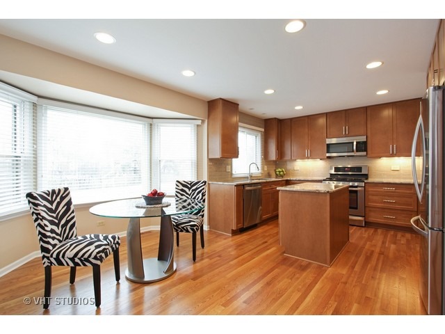 2109 Valley Road Northbrook, IL 60062 - Photo 5 of 13 a kitchen with stainless steel appliances kitchen island granite countertop a table chairs and a refrigerator