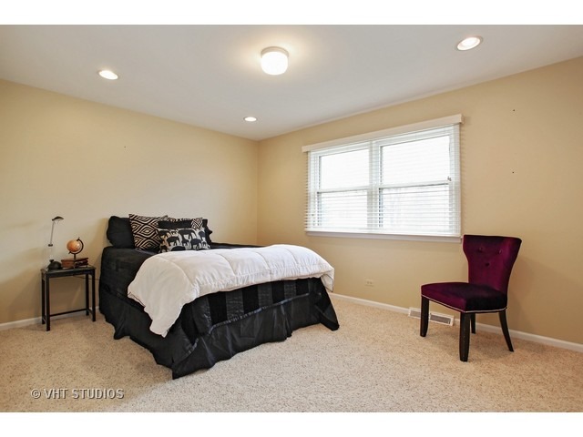 2109 Valley Road Northbrook, IL 60062 - Photo 8 of 13 a spacious bedroom with a bed and chair