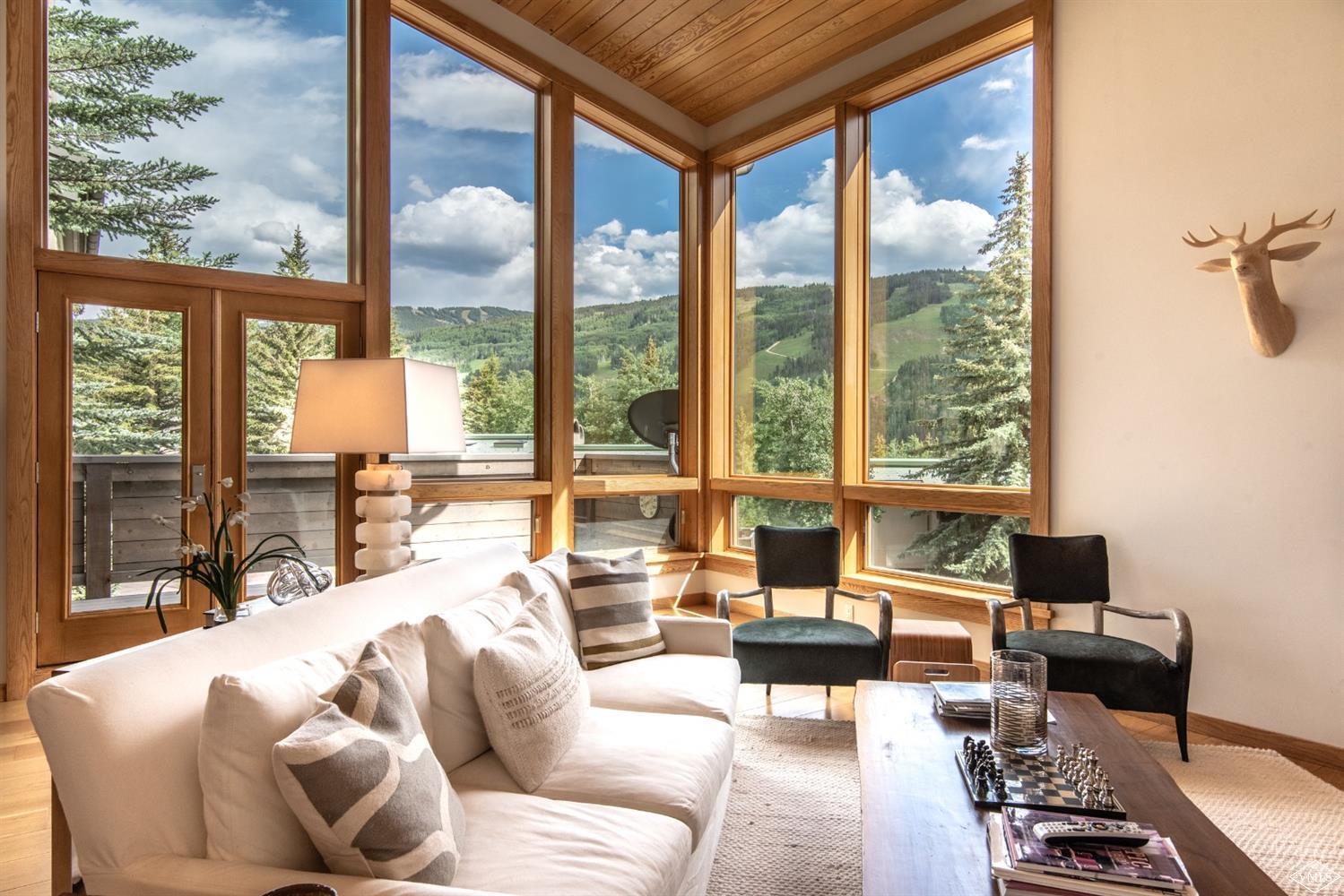 950 Red Sandstone Road, Unit 40 Vail, CO 81657 - Photo 1 of 23 a living room with furniture and floor to ceiling windows