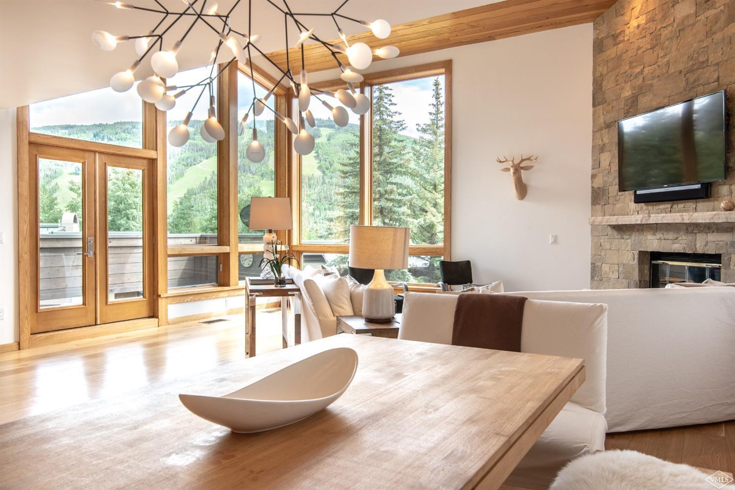 950 Red Sandstone Road, Unit 40 Vail, CO 81657 - Photo 3 of 23 a living room with furniture a flat screen tv and a floor to ceiling window