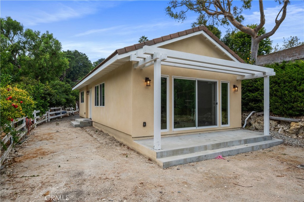 60 Ranchview Road, Unit 1/2 Rolling Hills Estates, CA 90274 - Photo 17 of 21 a view of a white house with a large windows and large trees