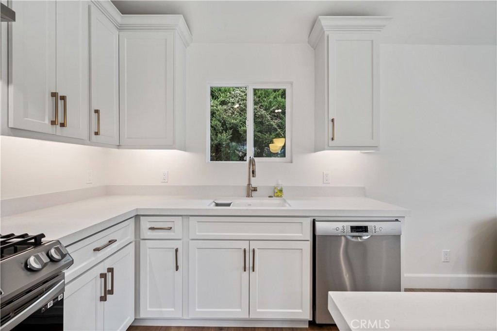 60 Ranchview Road, Unit 1/2 Rolling Hills Estates, CA 90274 - Photo 7 of 21 a kitchen with white cabinets a sink a stove and a window