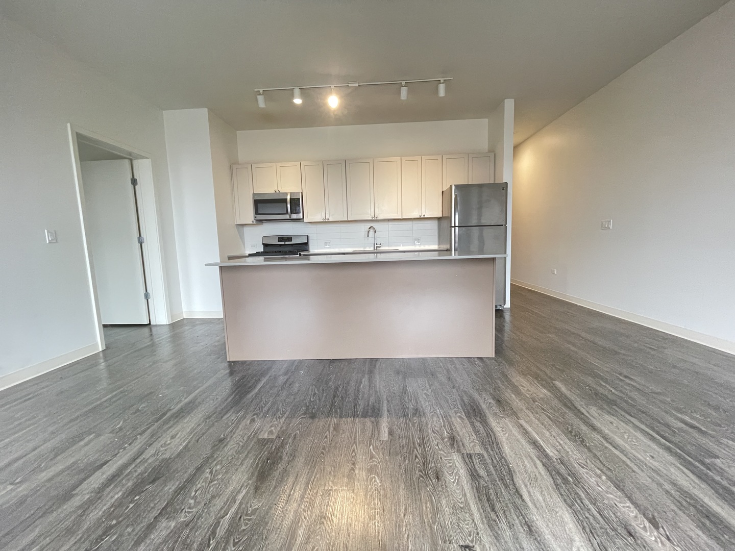 Undisclosed Address Chicago, IL 60642 - Photo 2 of 25 a kitchen with wooden floors and wooden cabinets