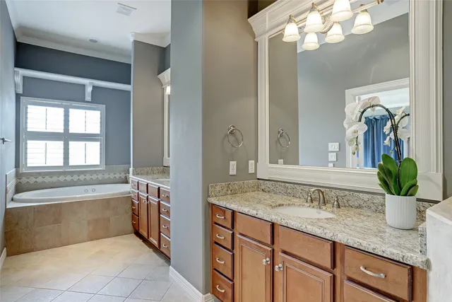 a bathroom with a granite countertop sink a large mirror a bathtub and next to a window