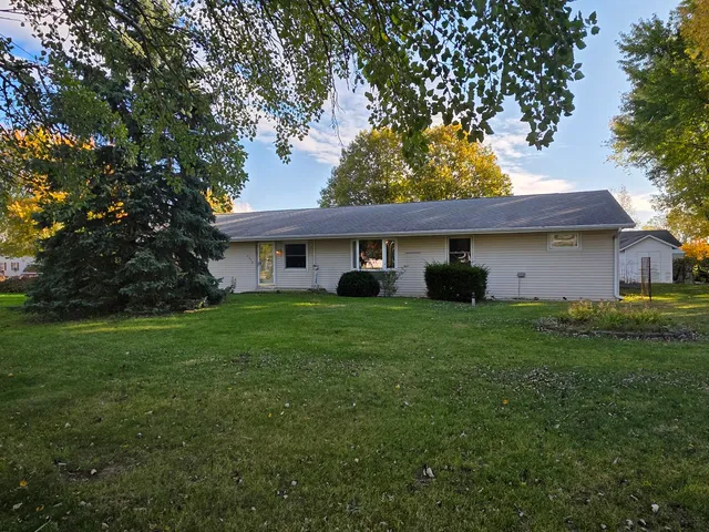 a view of a yard in front of a house with a large tree