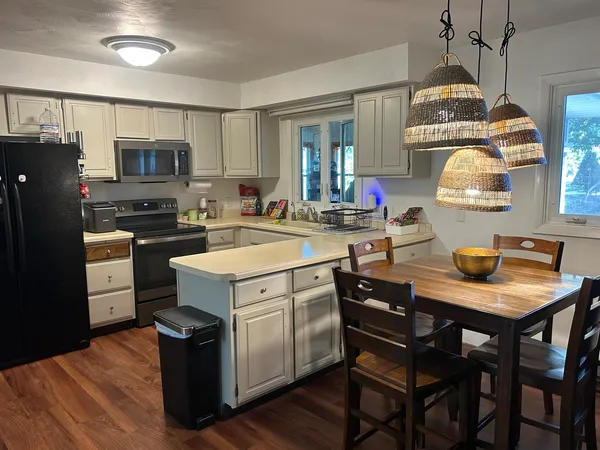 a kitchen that has a stove a table and chairs in it