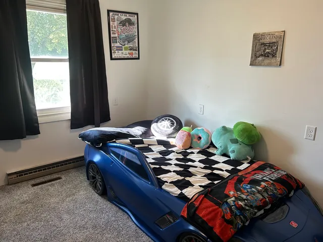 a bed sitting in a bedroom next to a window