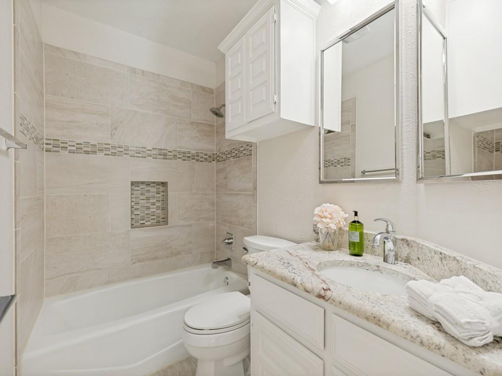 4010 Rive Lane Addison, TX 75001 - Photo 23 of 25 a bathroom with a granite countertop sink a toilet and bathtub