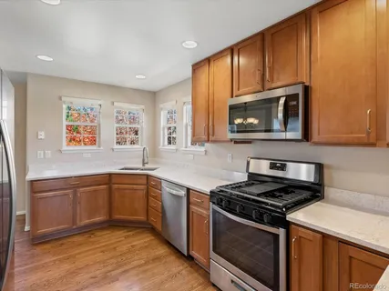 a kitchen with stainless steel appliances wooden cabinets and a stove top oven